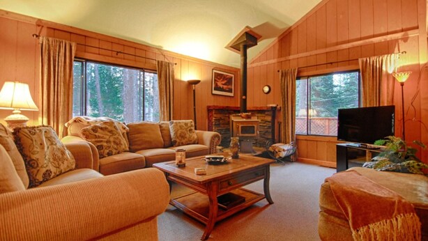 A cozy living room with a fireplace, comfortable seating, and a television. - The Bernstein Bear Cabin (Kings Beach)