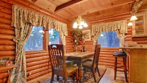 A log cabin with a wooden dining table, chairs, and a chandelier. - The Bernstein Bear Cabin (Kings Beach)