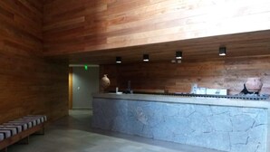 A reception area with a stone counter, wooden panel walls, and a bench along the wall.