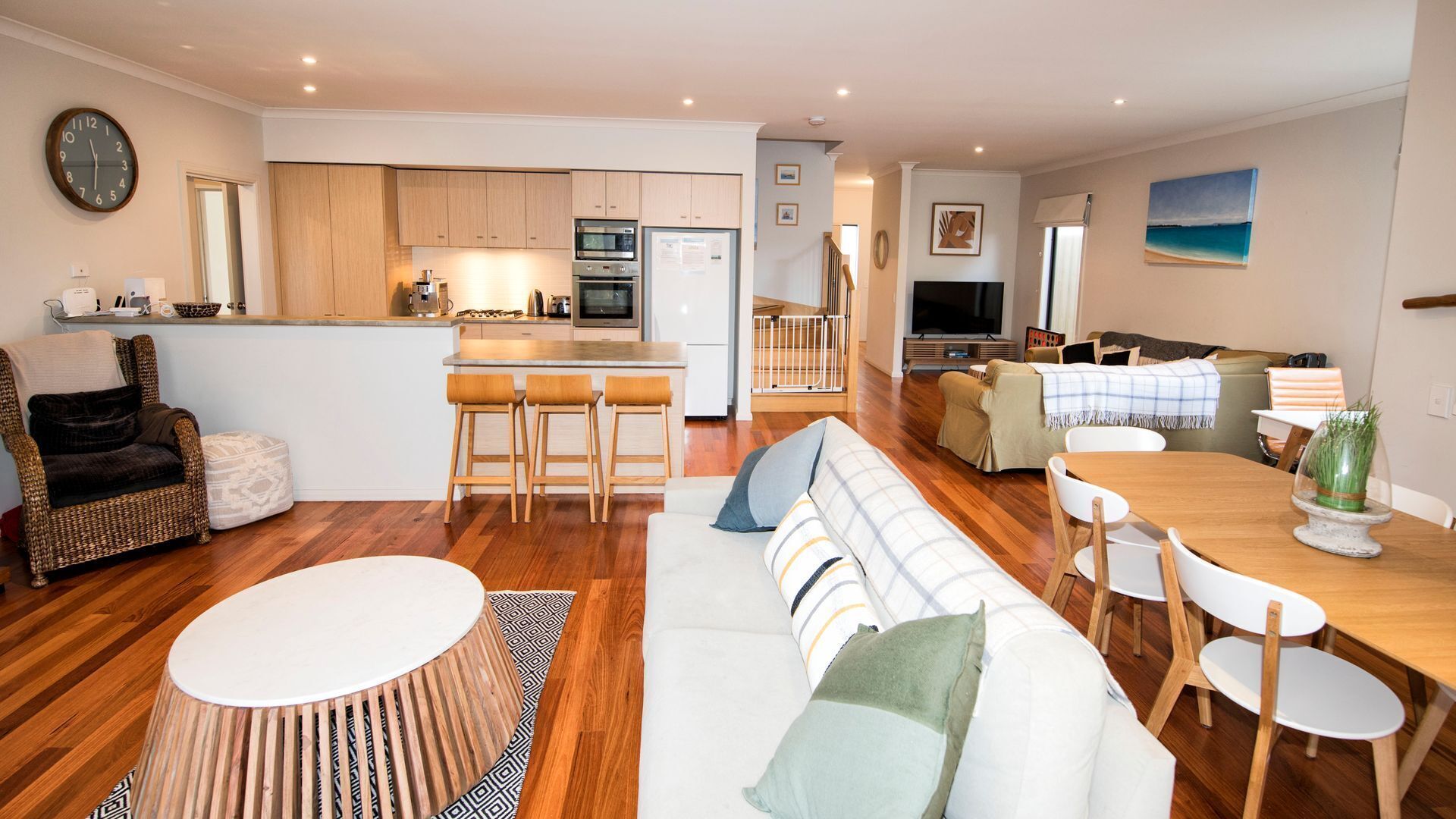 A modern living space with a kitchen, dining area, and seating.