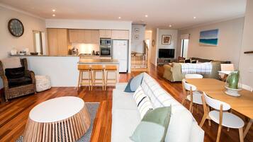 A modern living space with a kitchen, dining area, and seating.