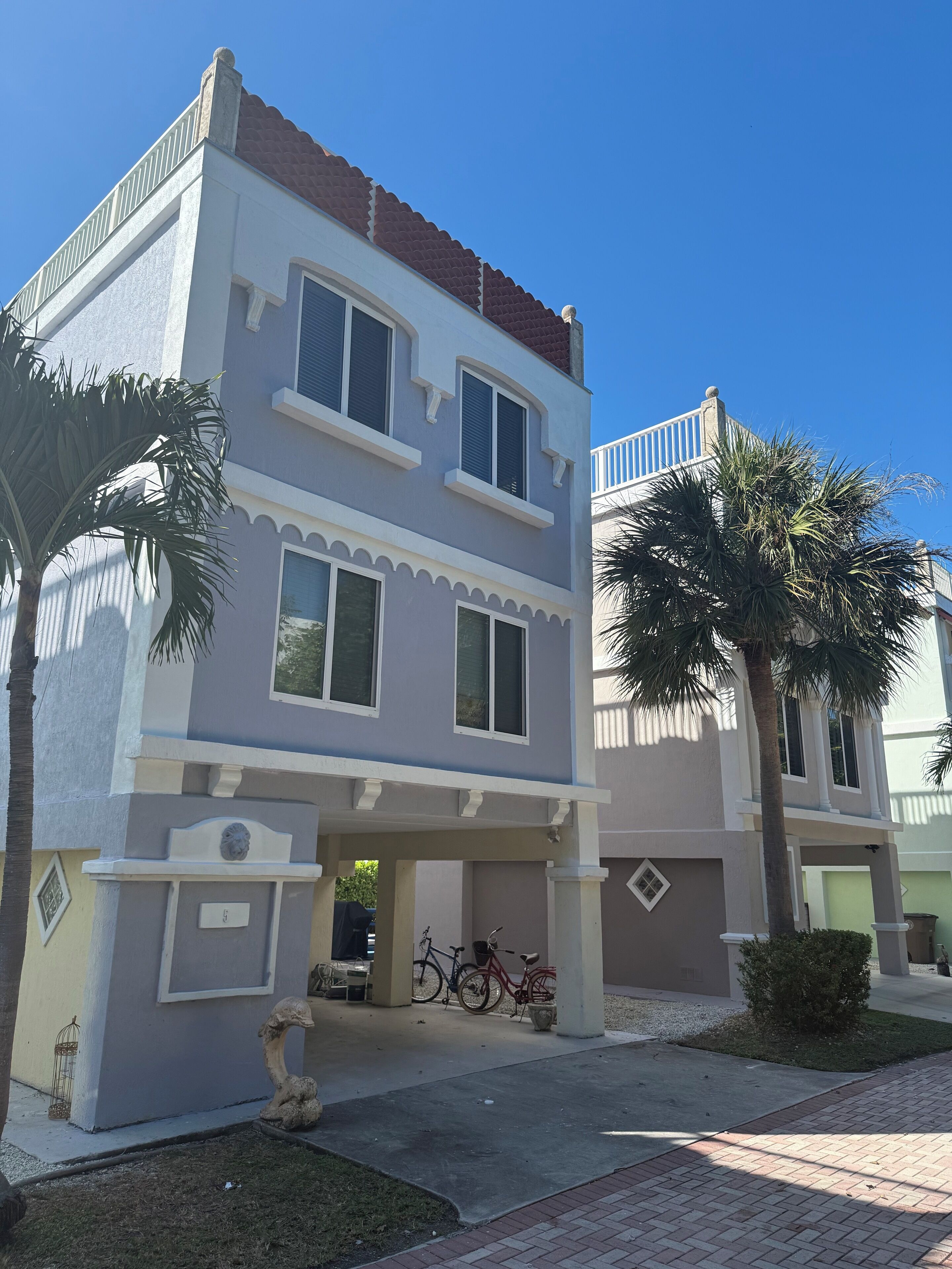 A two-story house with a balcony, a garage, and a driveway.