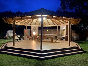 A covered outdoor seating area with a brick wall, a fireplace, and a grill. - Deluxe Triple Retreat – Perfect for Friends or Small Families (Urubamba)