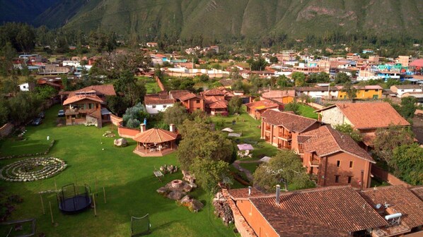 A residential area with houses featuring red-tiled roofs, surrounded by greenery and mountains. - Deluxe Triple Retreat – Perfect for Friends or Small Families (Urubamba)