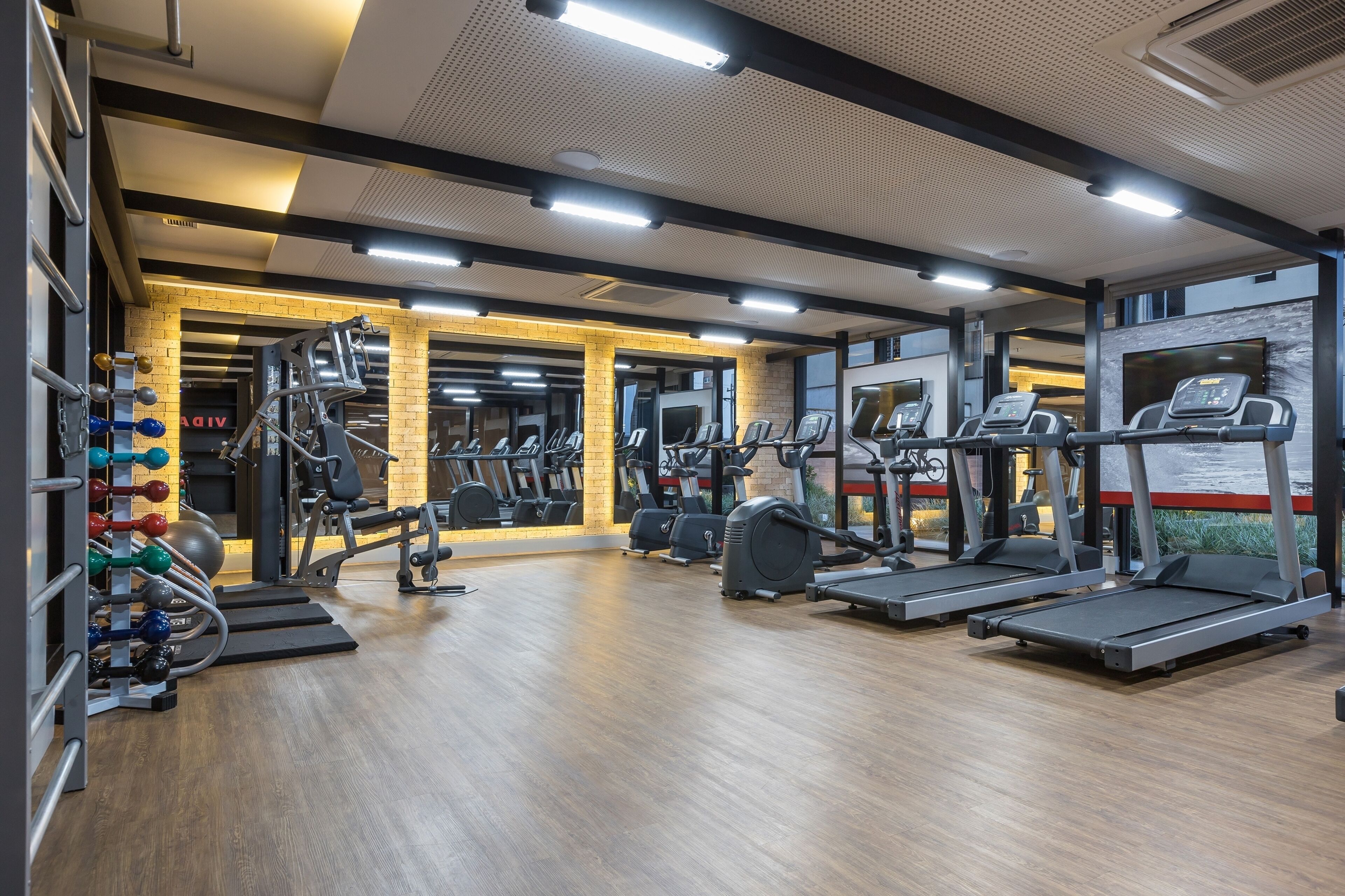 Een sportschool met loopbanden, elliptische trainers en gewichten.