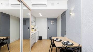 A modern kitchen with white cabinets, a wooden countertop, and a built-in oven.