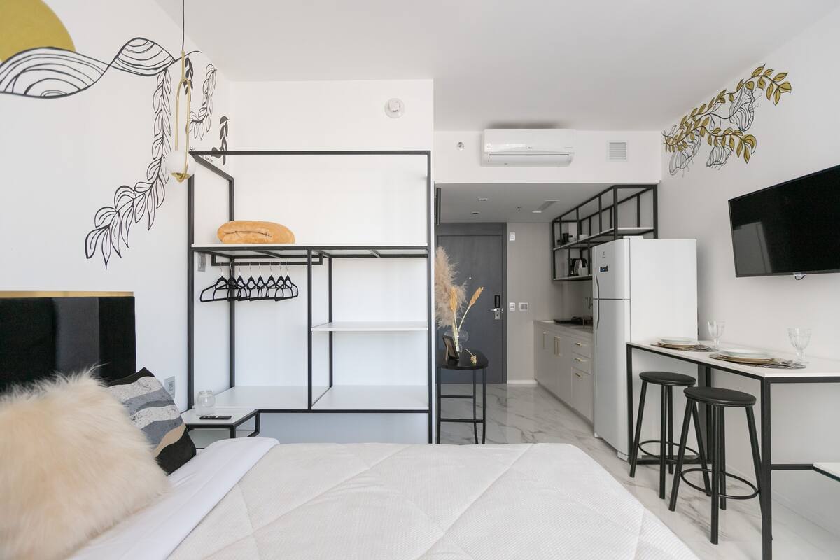Une chambre moderne équipée d’un lit, d’un bureau et d’une kitchenette.