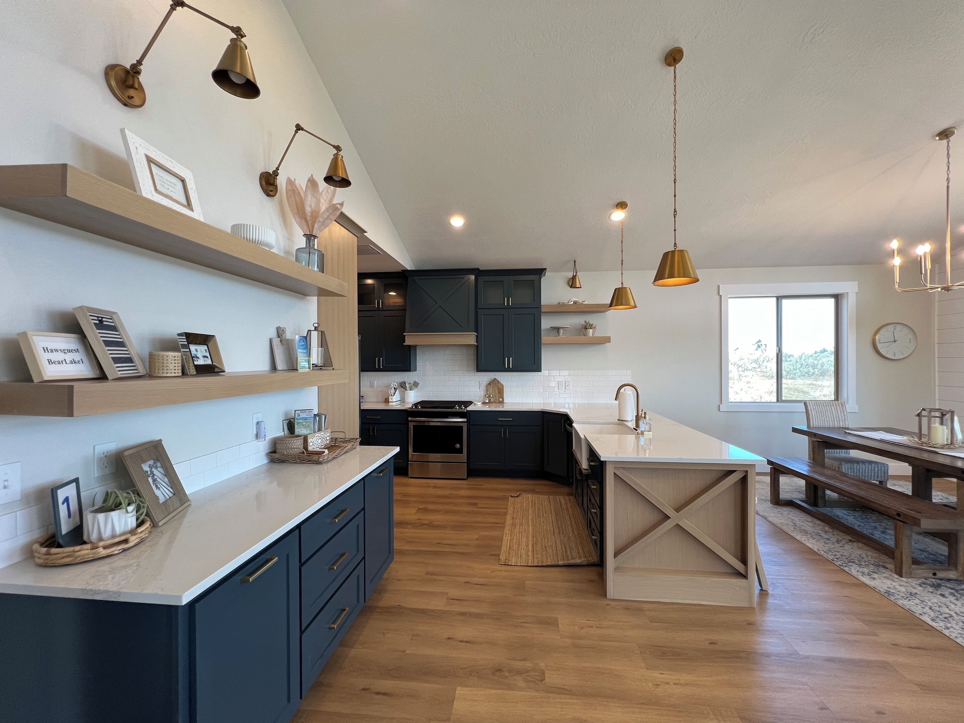 A modern kitchen with dark blue cabinets, a central island, and pendant lighting.