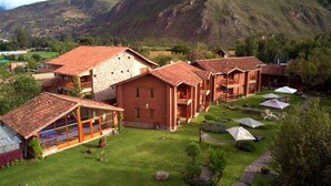 Ein Hotel mit mehreren Gebäuden, einem gepflegten Rasen und einer Bergkulisse.