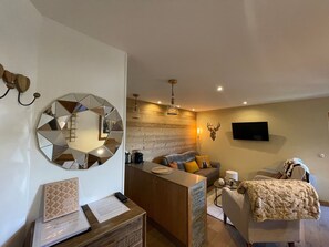 Relax in this stylish living area with a sofa, chair, and flat-screen TV.