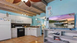 A kitchen with white cabinets, a microwave, and a wooden ceiling. - Coco Sands Studios (Cocoa Beach)