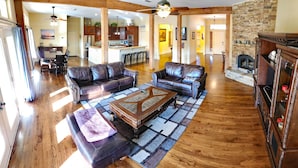 A spacious living room with leather sofas, a coffee table, and a fireplace. - Huge 4 bedroom + loft lakehouse with private dock - 27 min north of Sundance Sq  (Fort Worth)