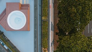 A rooftop with a circular hot tub, a narrow pathway, and dense greenery. - Cost-effective enjoyable Studio in Laureles with A/C (Medellín)