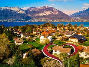 Zona residencial con casas, una carretera sinuosa y montañas al fondo.