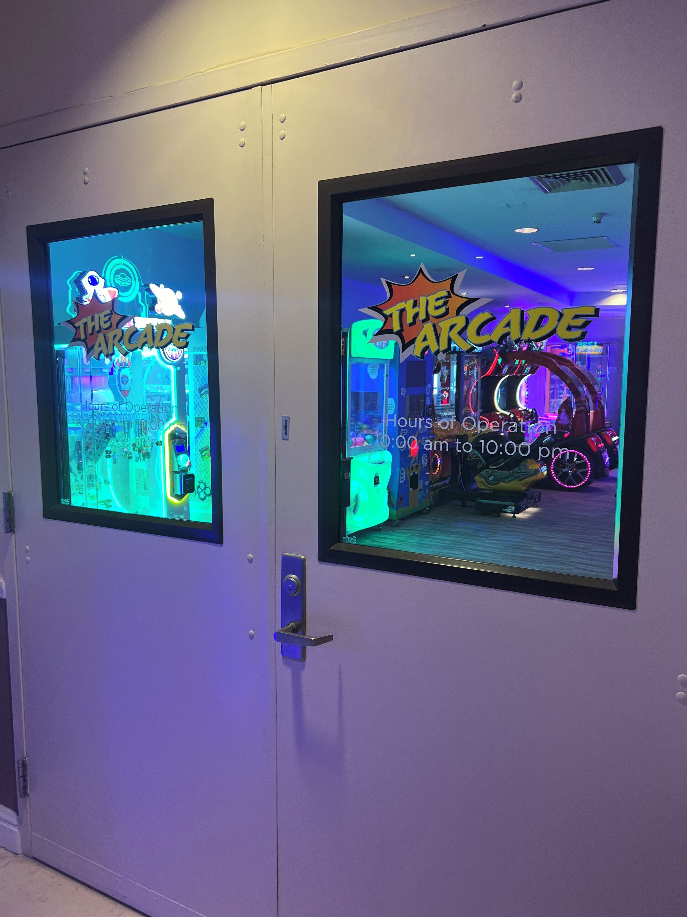 Twee speelhalruimtes met neonborden, elk met de tekst 'The Arcade' en 'Openingstijden van 10:00 tot 22:00.'