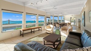 A spacious living area with large windows, a dining area, and a view of the ocean. - High End Oceanfront Home, a 2 min walk to Beach, Shops, Dining & More in Solana (Solana Beach)