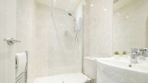 A modern bathroom with a shower, toilet, and sink. - Highcliffe Seaview Suite (Blackpool)