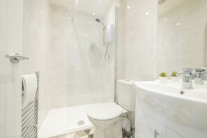 Un baño moderno con ducha, inodoro y lavabo.