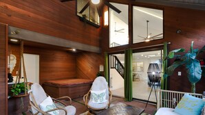 A wooden interior with a seating area, a bed, and a staircase leading to an upper level.