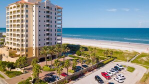 A high-rise hotel with multiple balconies, a parking lot, and a beach view. - Ocean View! 100 steps to feet in the sand! Super Clean! (Jacksonville Beach)