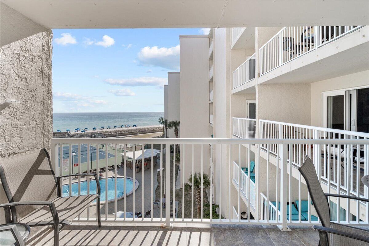Ein Balkon mit Blick auf Pool und Strand.