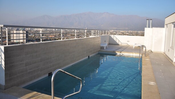 Une piscine sur le toit offrant une vue dégagée sur les montagnes en arrière-plan.