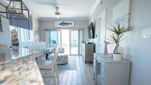Une cuisine spacieuse avec un coin repas, un ventilateur de plafond et une grande fresque représentant des poissons sur le mur.
