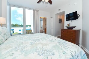 A bedroom with a large bed, a TV, a dresser, and a view of the outdoors. - 4th Floor condo at The Palms of Destin with Seasonal Beach Shuttle! (Destin)