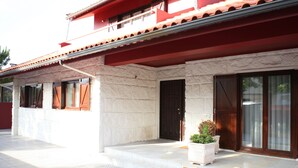 A building with a red roof, stone walls, and large wooden doors.