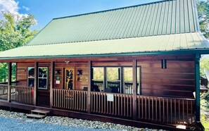 Un bâtiment en bois surmonté d’un toit en métal, doté d’un porche avec une balustrade et d’une enseigne indiquant « Papa Wolf’s Cove ».