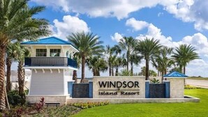 Señal para el Windsor Island Resort, con un edificio moderno y palmeras.