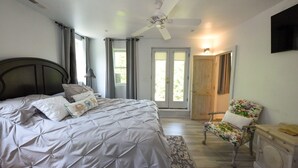 A bedroom with a bed, a chair, a ceiling fan, and a door leading outside. - Spring and Summer are on the way! Book your stay Today! (West Cape May)