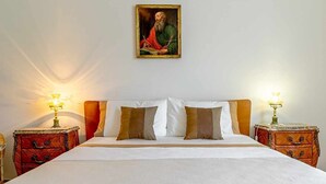 A neatly made bed with white linens and two brown pillows, flanked by wooden nightstands with lamps. - La Casa di Elvira - Sea View (Giardini Naxos)