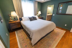 A neatly arranged bedroom with a bed, nightstands, a mirror, and a window with curtains. - World Traveler's - Phenomenal Getaway Retreat with Spacious Backyard Paradise to Enjoy! (Flagstaff)