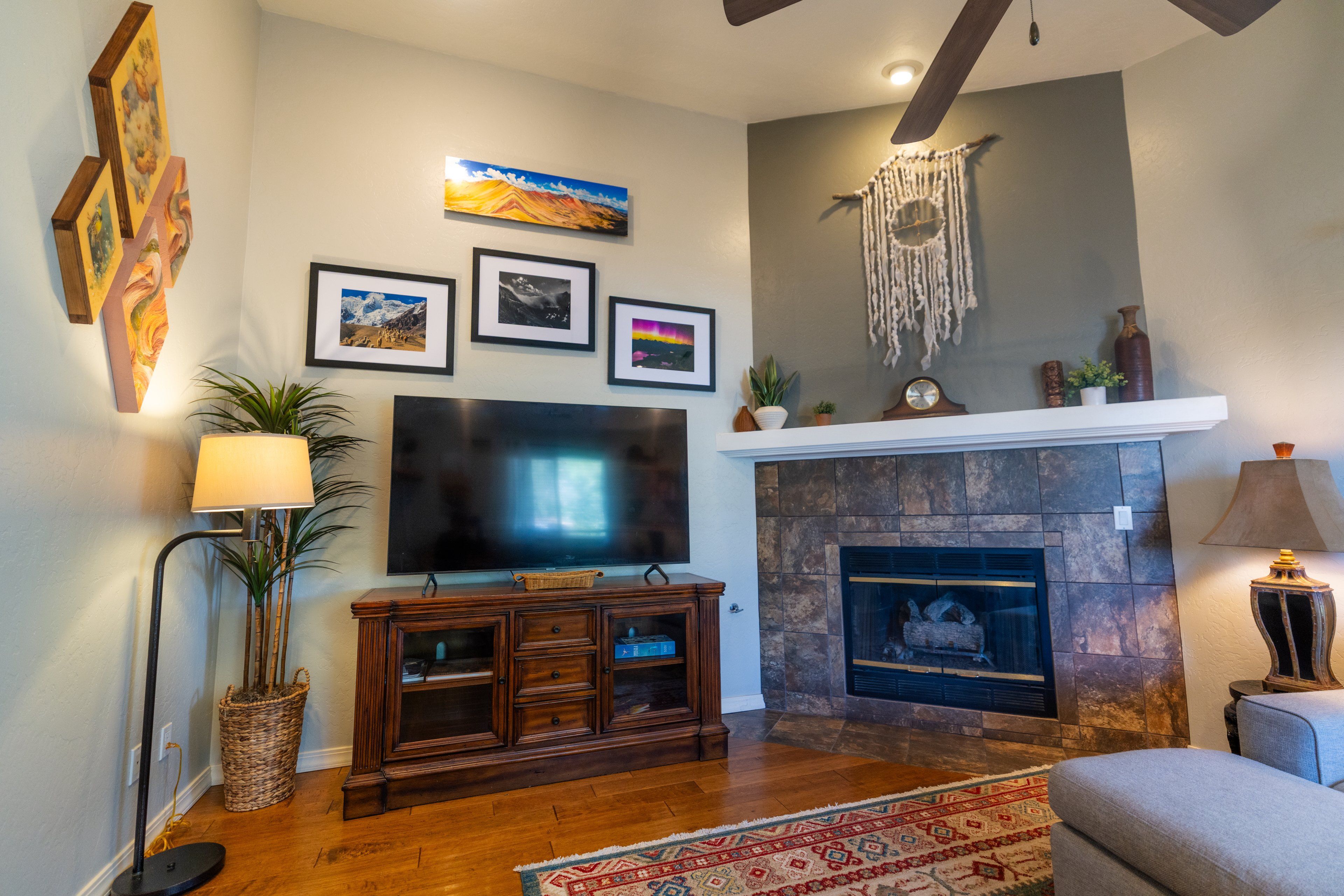 Una sala de estar con televisor de pantalla plana, chimenea y obras de arte colgadas en la pared.