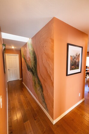 A hallway with a textured wall and a framed picture. - World Traveler's - Phenomenal Getaway Retreat with Spacious Backyard Paradise to Enjoy! (Flagstaff)