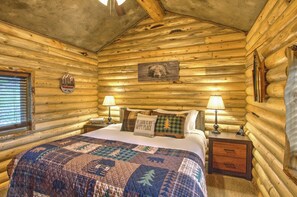 A log cabin bedroom with a bed, two nightstands, a window, and a bear headboard. - Cozy and Rustic "Bear Themed" Cabin~private pond and 7 miles to YNP entrance! (West Yellowstone)