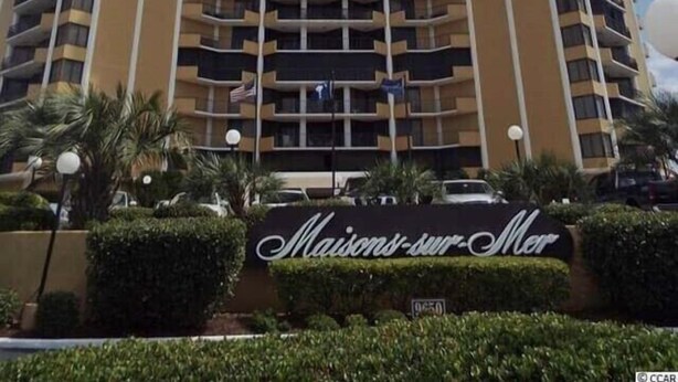 Een hoog, meerlaags hotel met een symmetrische gevel, met balkons op elk verdiep.