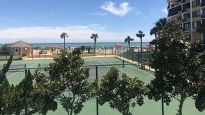 Een tennisbaan met uitzicht op het strand en de oceaan.
