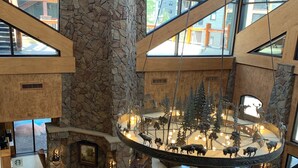 A spacious lobby with a stone fireplace, seating area, and a central decorative display. - ⛷️ SKI ONTO THE SLOPES • ⛳️ WALK ONTO THE LINKS • 🏔️ WESTGATE PARK CITY  (Park City)