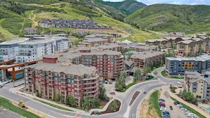 A modern hotel complex with multiple buildings, a central courtyard, and a view of surrounding hills. - ⛷️ SKI ONTO THE SLOPES • ⛳️ WALK ONTO THE LINKS • 🏔️ WESTGATE PARK CITY  (Park City)