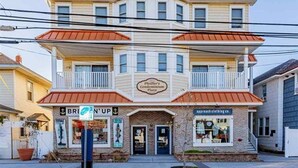 A multi-story building with a sign for "Feifer's Condominium Plaza" and a storefront named "BREN'N'UP."