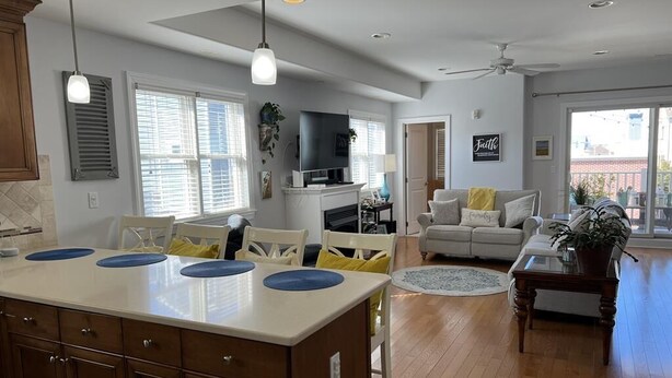 A spacious living area with a kitchen island, dining table, and seating.