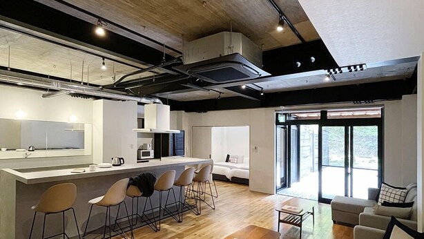 A modern hotel interior with a kitchen, dining area, and living room. - bHotel Kaniwasou (Hatsukaichi)