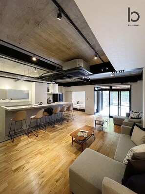 A modern hotel interior with a kitchen, dining area, and living room.