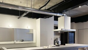 A modern kitchen with a central island, bar stools, and a visible kitchen counter. - bHotel Kaniwasou (Hatsukaichi)
