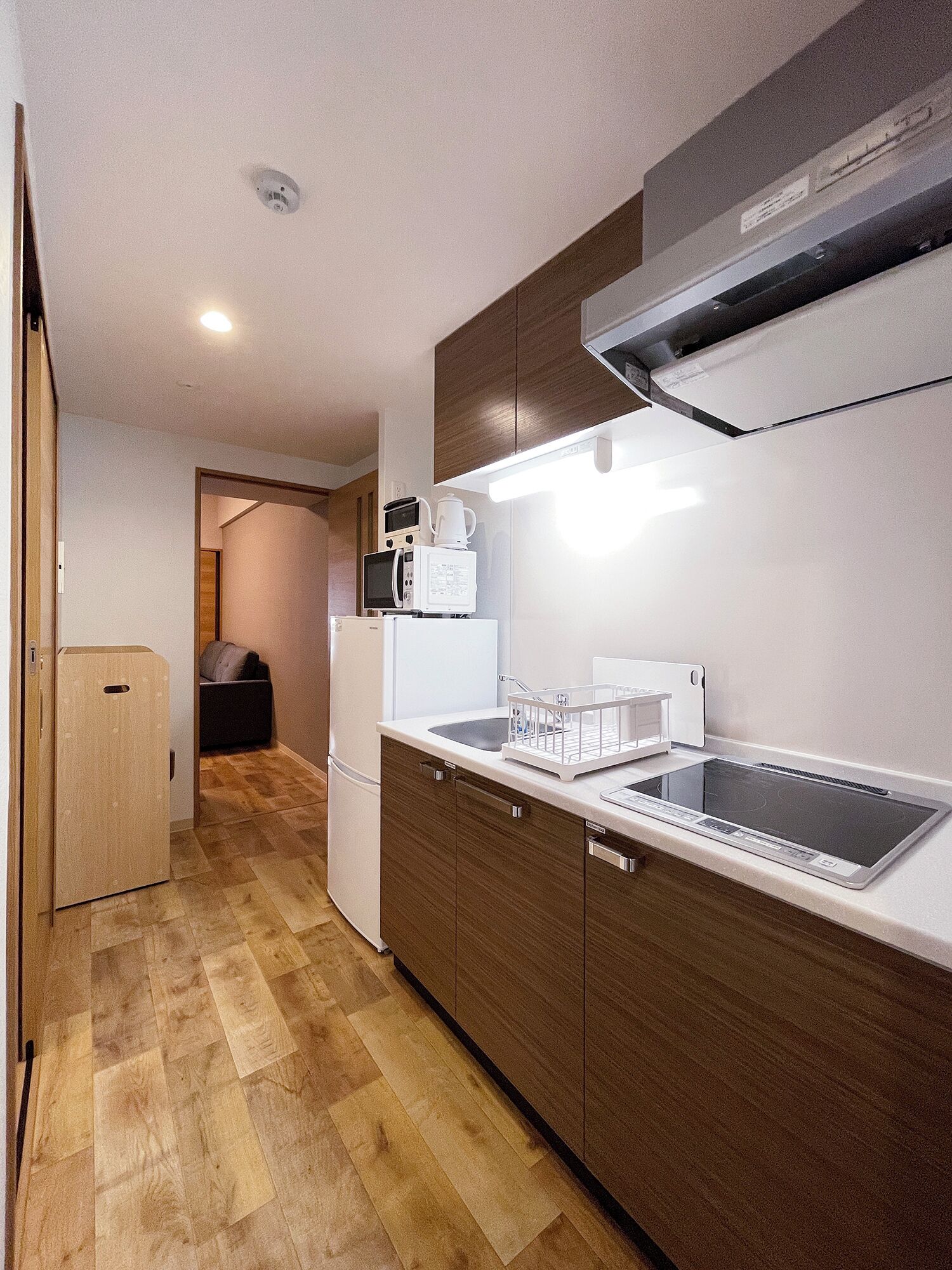 A modern kitchen with a built-in microwave, coffee maker, and a large induction cooktop.