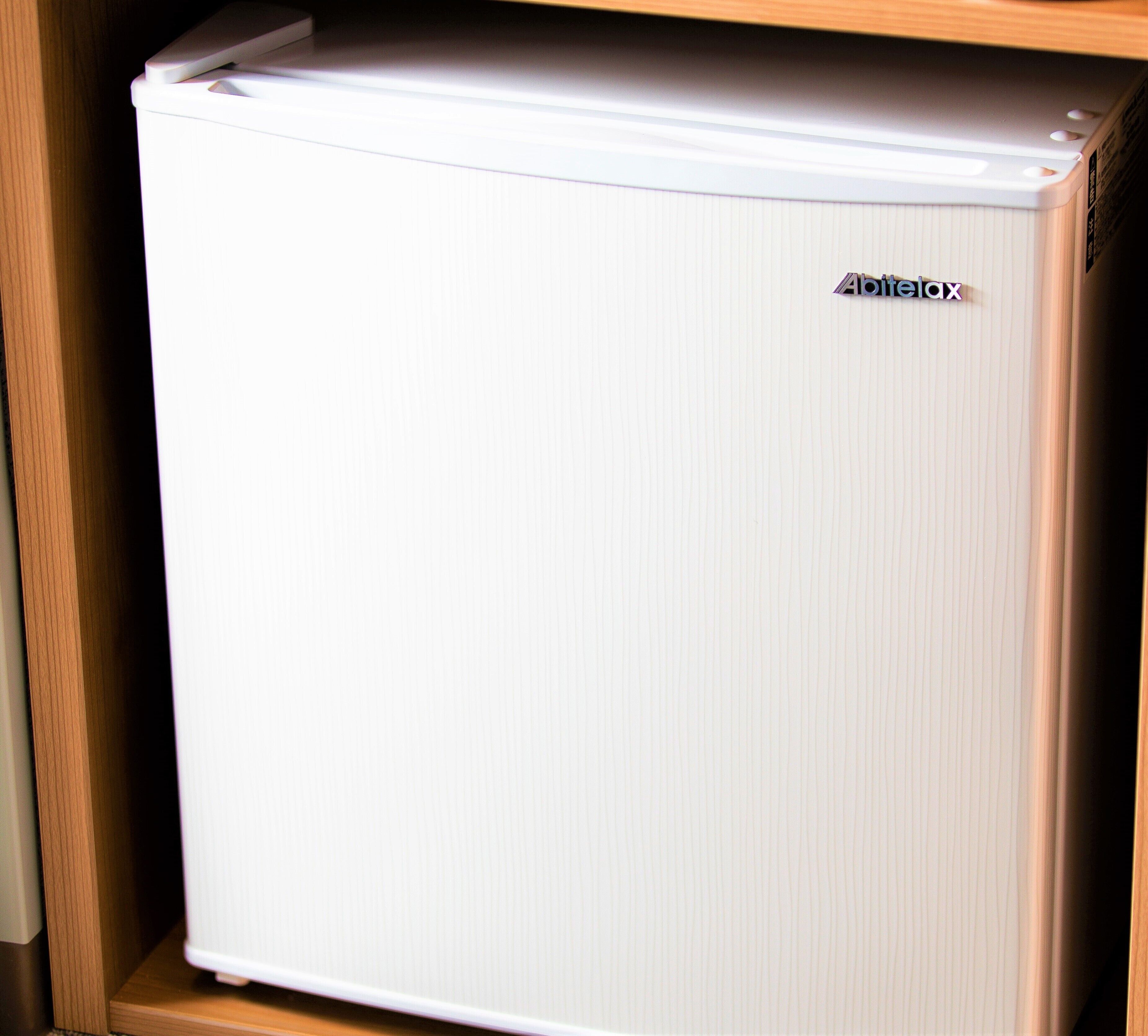 Un mini refrigerador blanco con el nombre de marca '4play' en la parte superior.