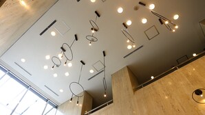 Un intérieur moderne avec un plafond haut, des luminaires encastrés et un plancher en bois.
