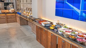 Un buffet proposant une variété de plats et d'ustensiles.